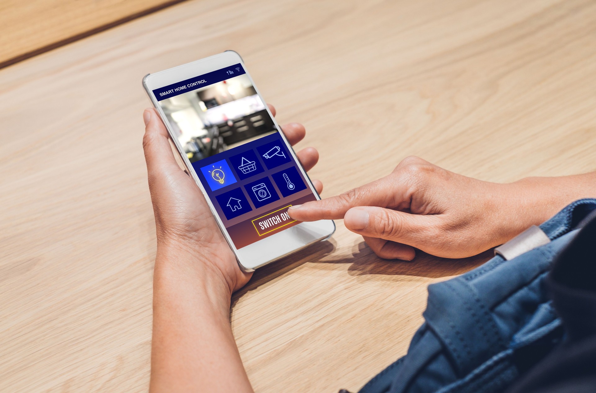 Close up hand use smart home control app on mobile phone switch on light.Automation digital technology.